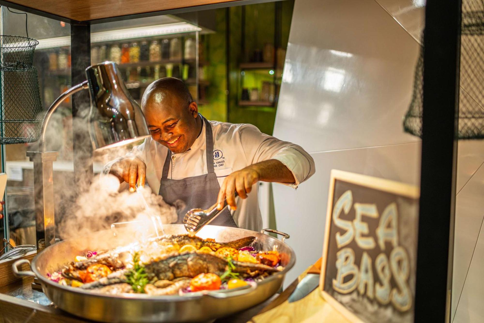Hotel Hilton Bahrain Manama Exterior foto Chef preparing food at the Sea Bass restaurant